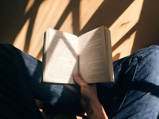 alt="A man reading a book"