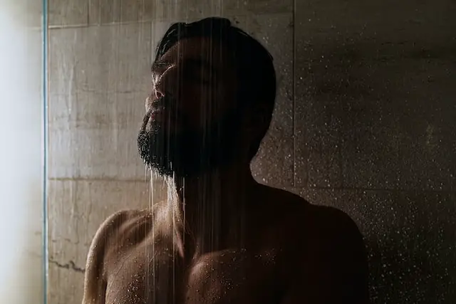 alt="A man taking shower"